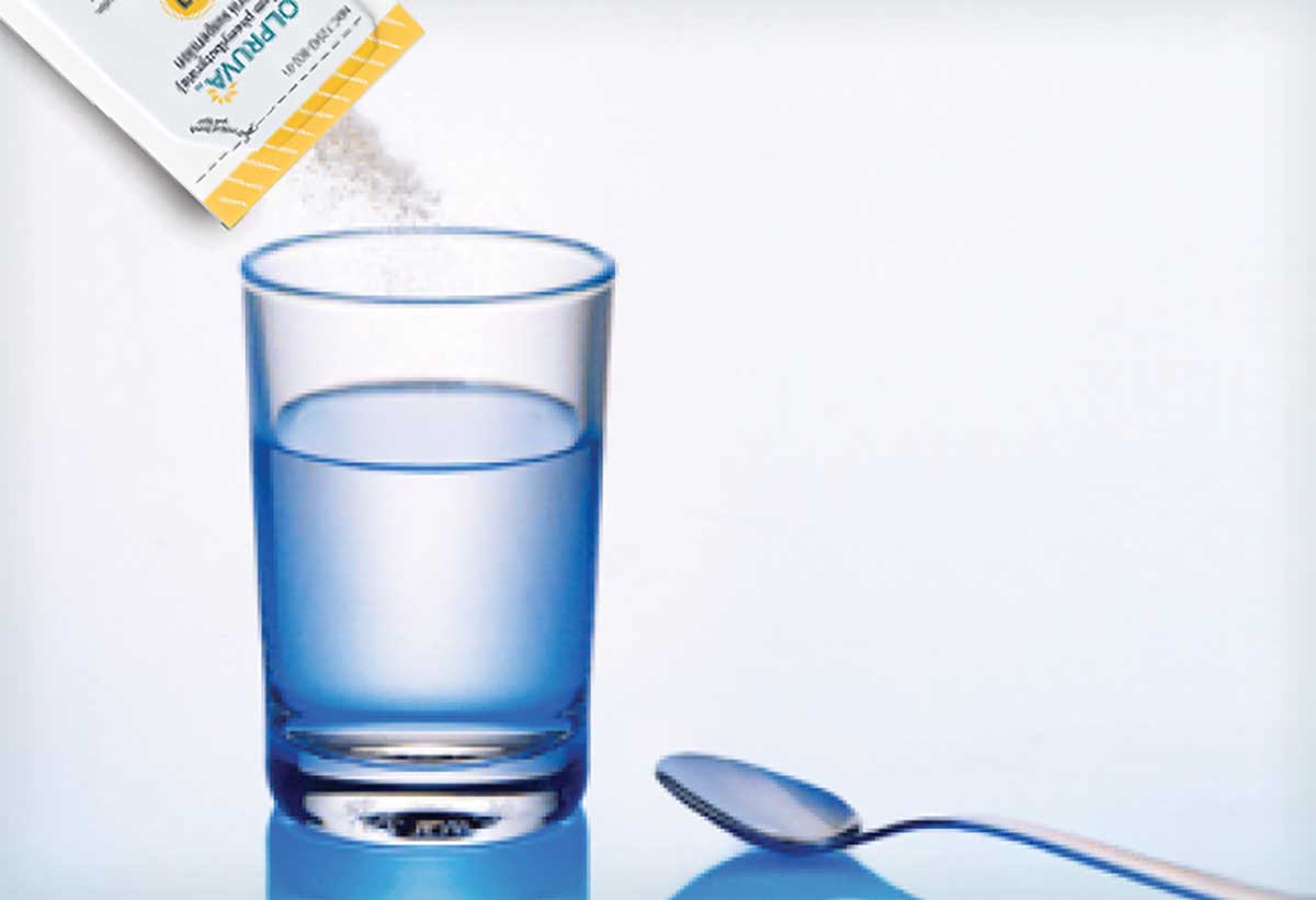OLPRUVA packet pouring over a glass of water, demonstrating easy, premeasured preparation for the treatment of certain UCDs.